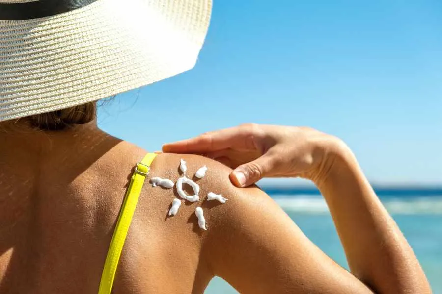 woman applying sunscreen at beach